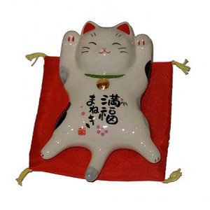 Chat maneki neko allongé.